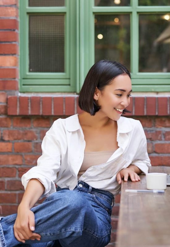 portrait-of-young-stylish-woman-influencer-sitting-in-cafe-with-cup-of-coffee-and-laptop-smiling.jpg